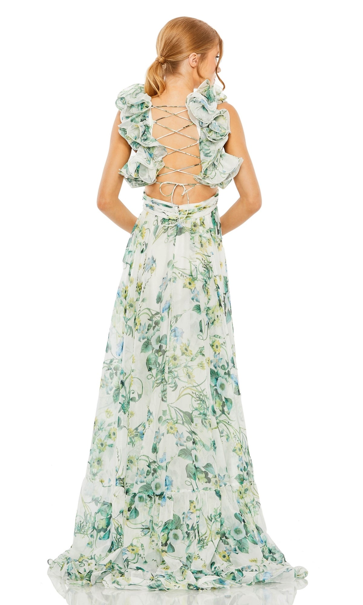 Woman in the Long Formal Dress 68521 by Mac Duggal—a flowing green A-line dress featuring floral details, ruffles, and an open lace-up back—standing and facing away.